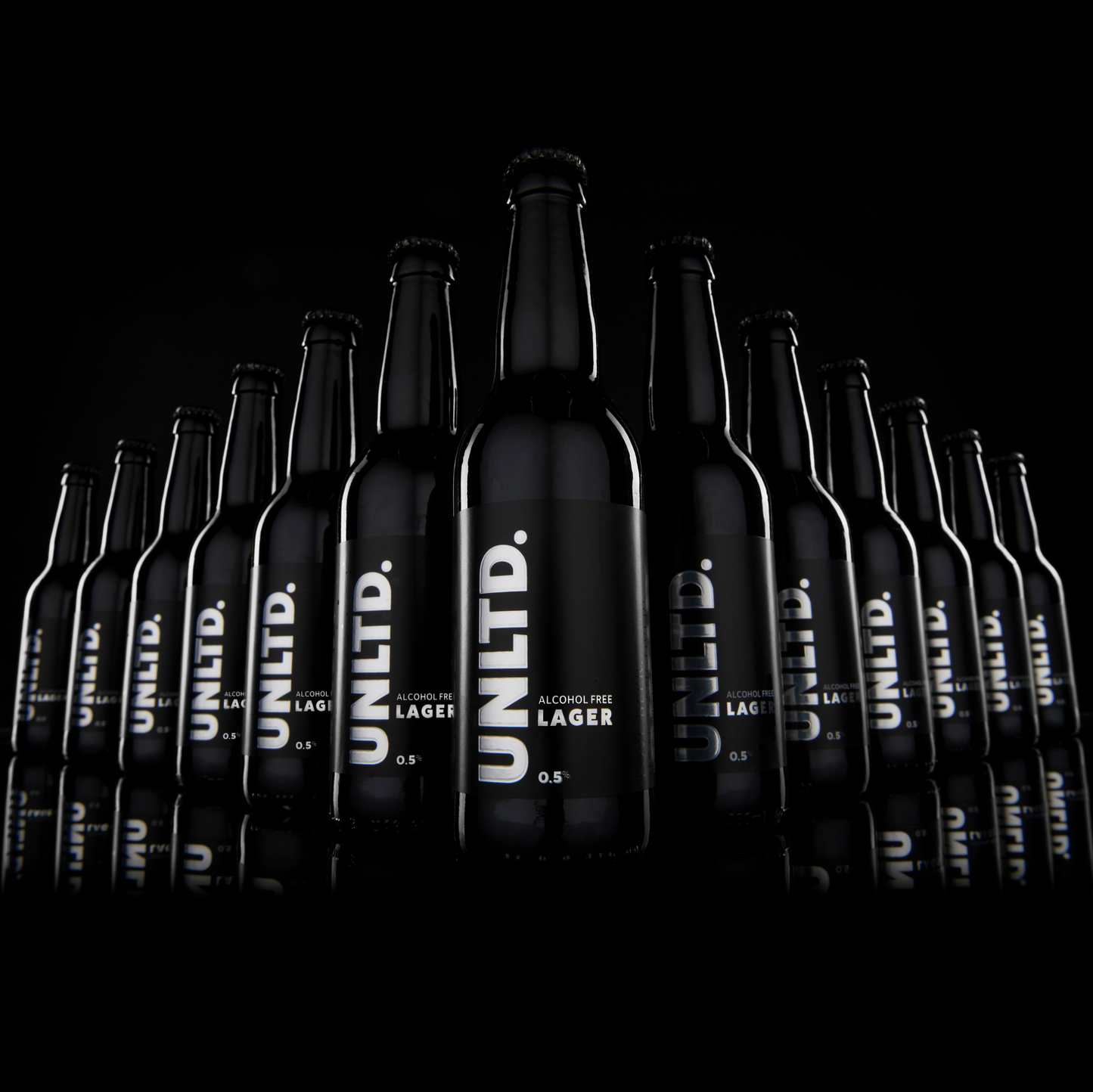 
                  
                    Row of UNLTD. Lager bottles on a black background
                  
                